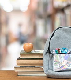 Books and backpack on shelf in library