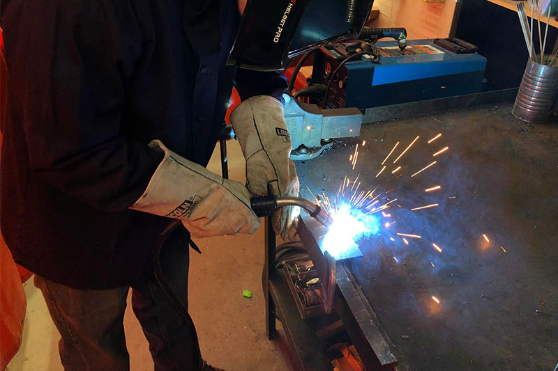 Student welding in the warehouse